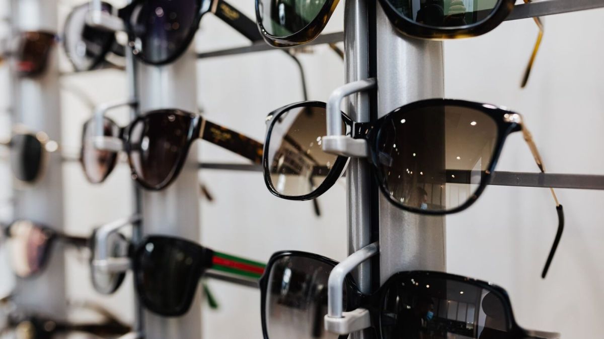 Close-up view of stylish sunglasses displayed on a rack in a retail store.