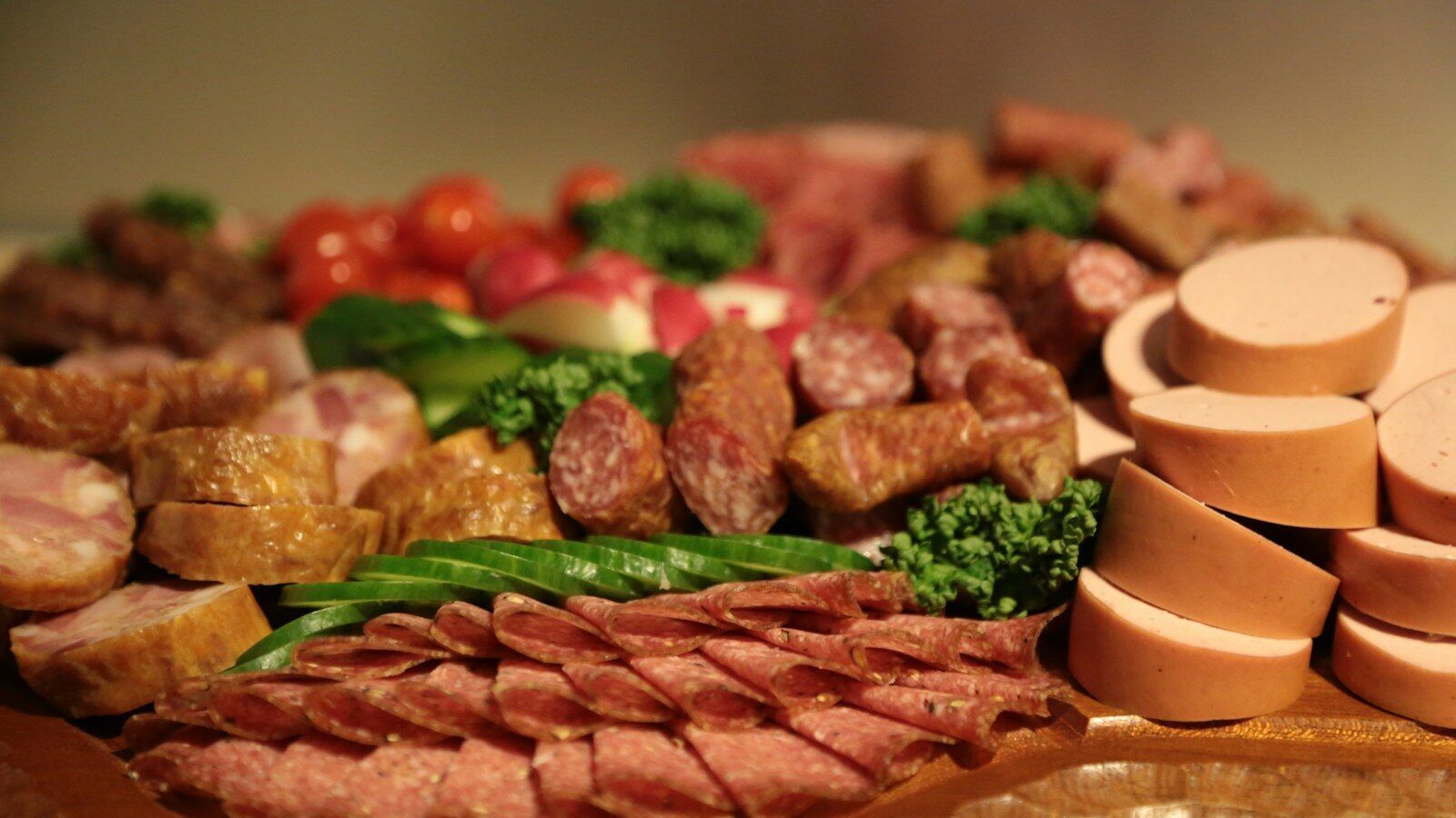 sliced meat with green vegetable on brown wooden round plate