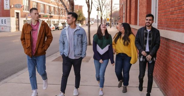 three men and laughing two women walking side by side