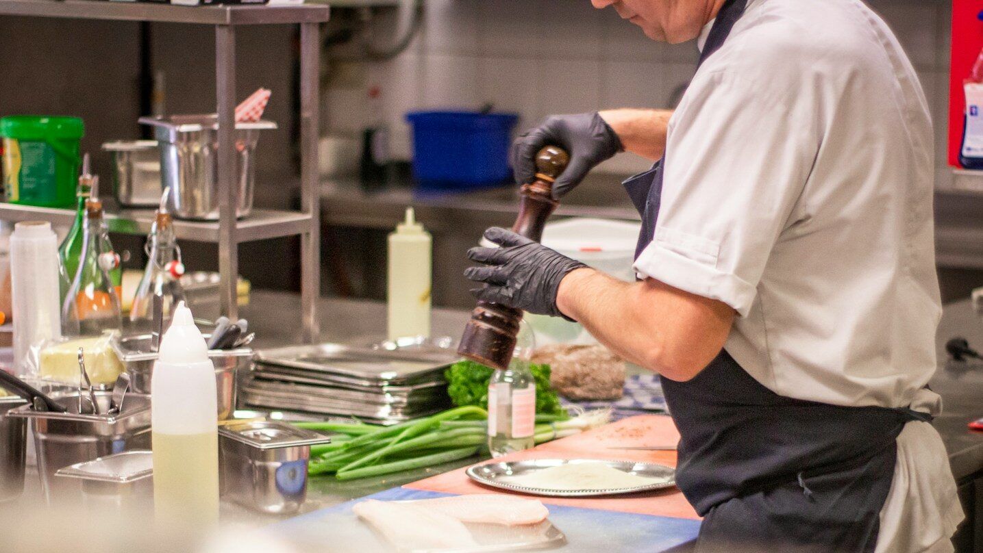 man putting herb on food