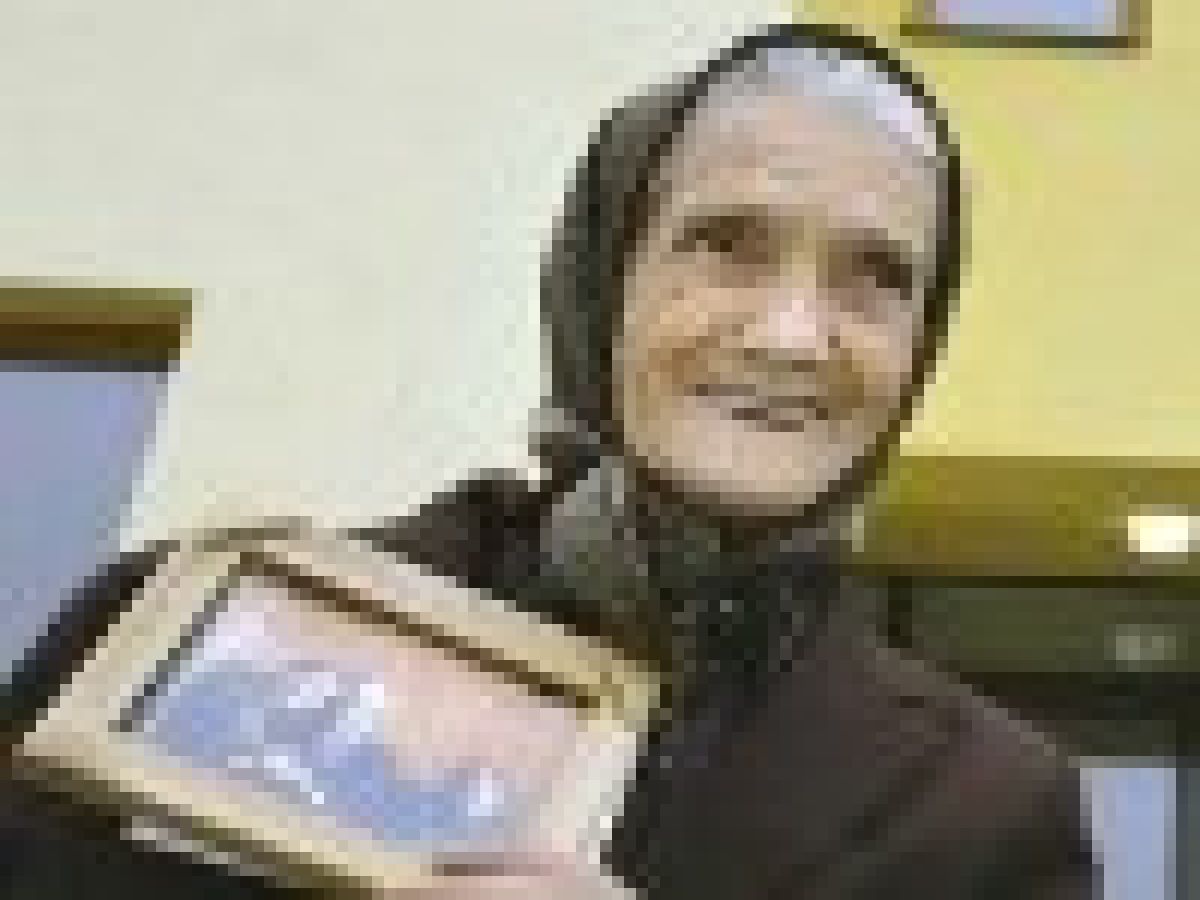 baba Lena pozira pred zgradata