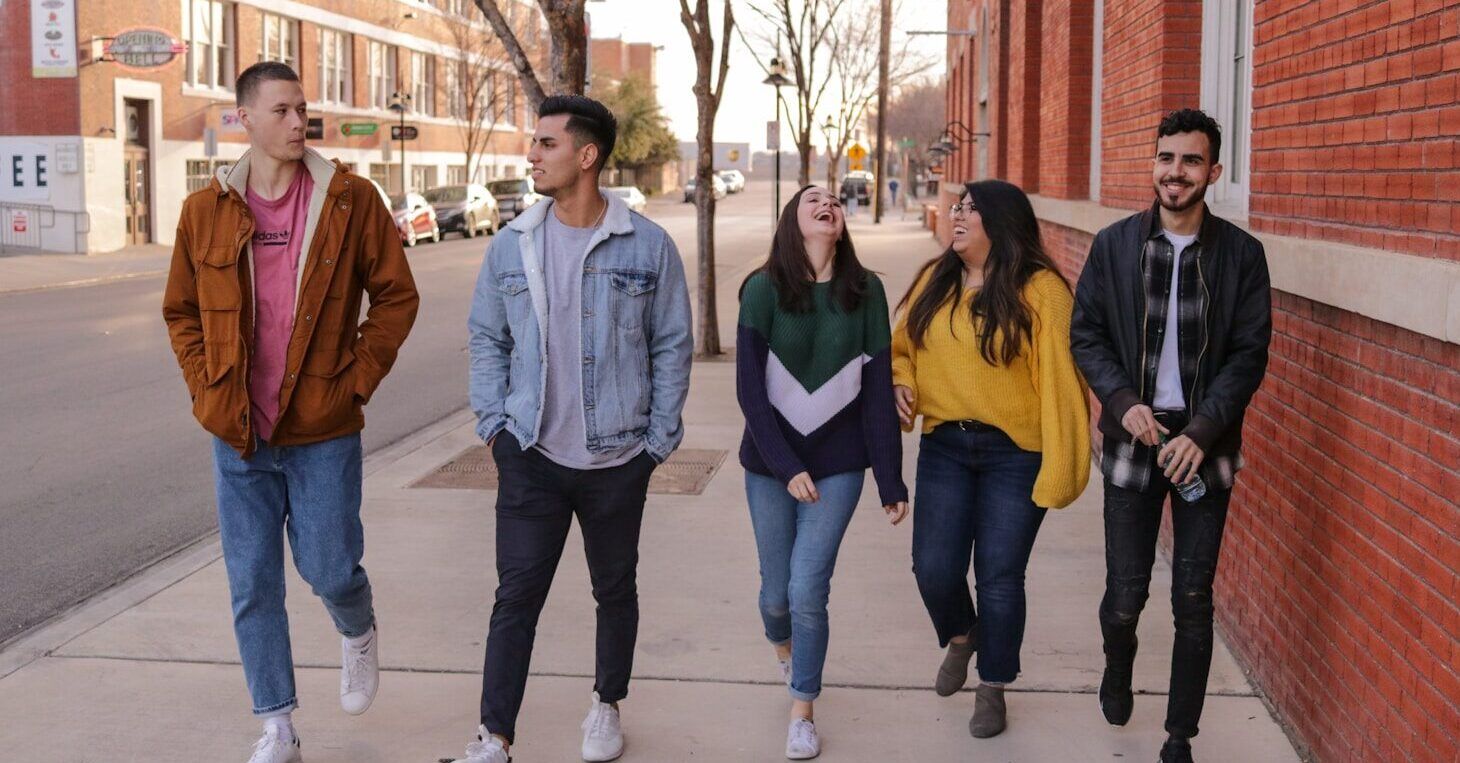 three men and laughing two women walking side by side