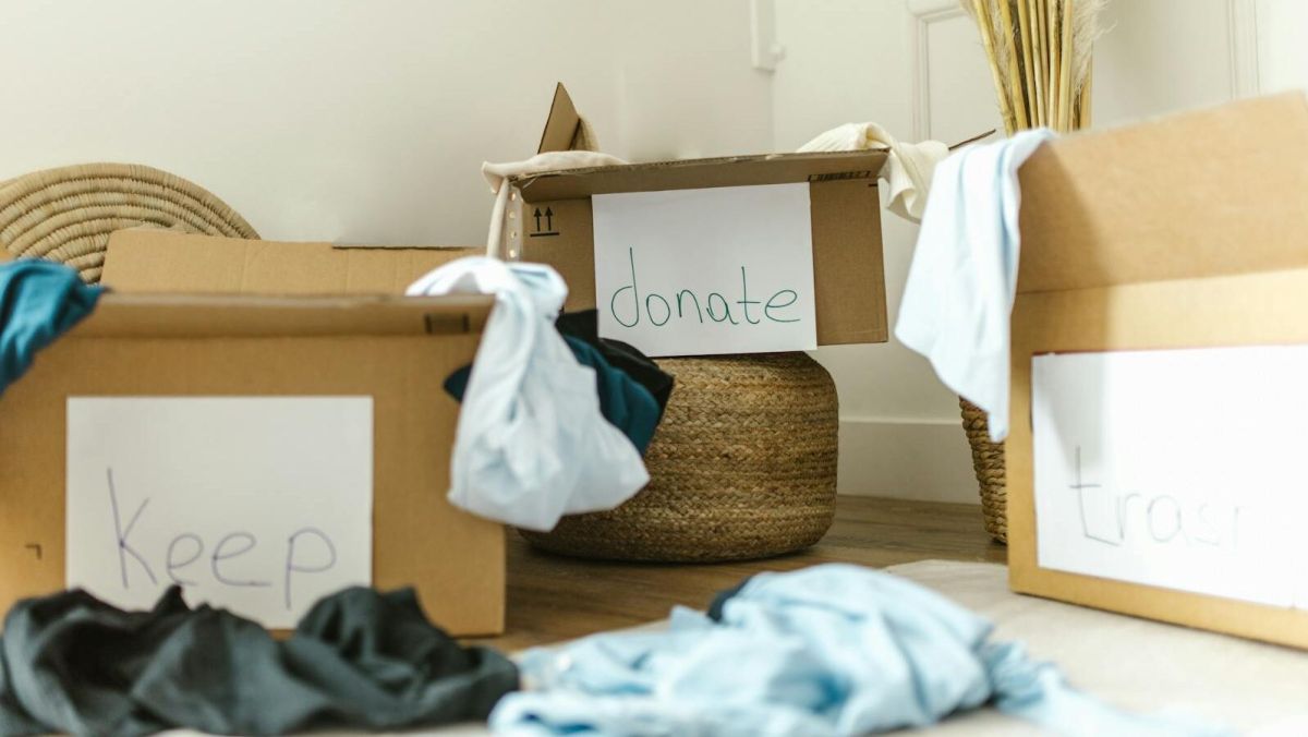 Cardboard boxes labeled keep, donate, and trash for effective home organization.