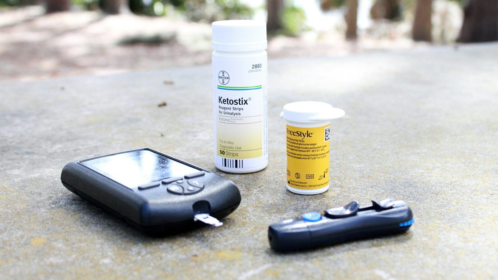 black smartphone beside white plastic bottle and black smartphone