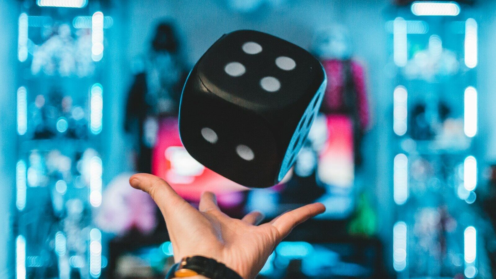 person's left palm about to catch black dice