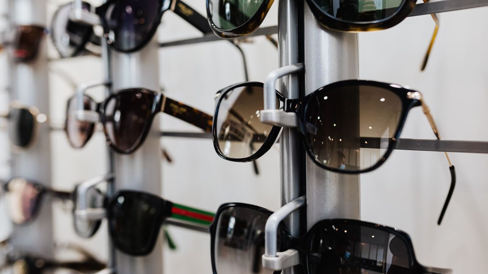 Close-up view of stylish sunglasses displayed on a rack in a retail store.