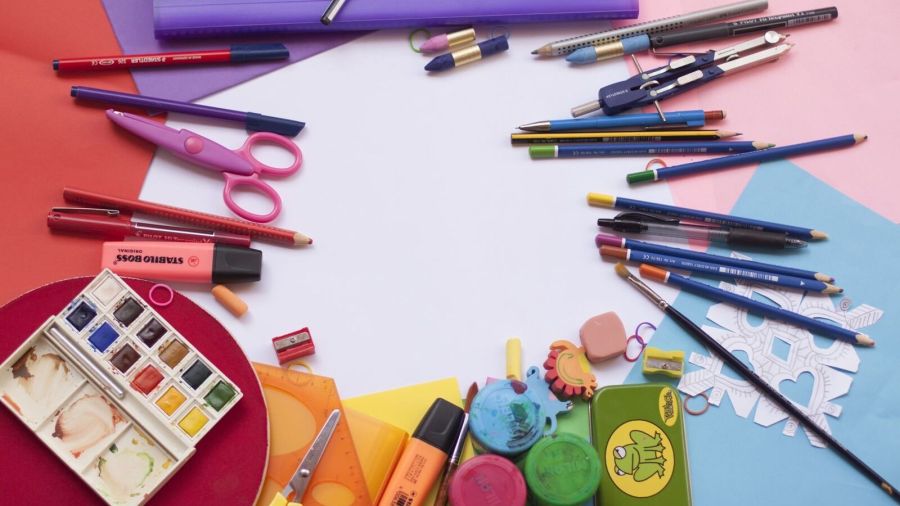 A vibrant selection of school supplies on a desk, including paints and stationery, ideal for creative projects.