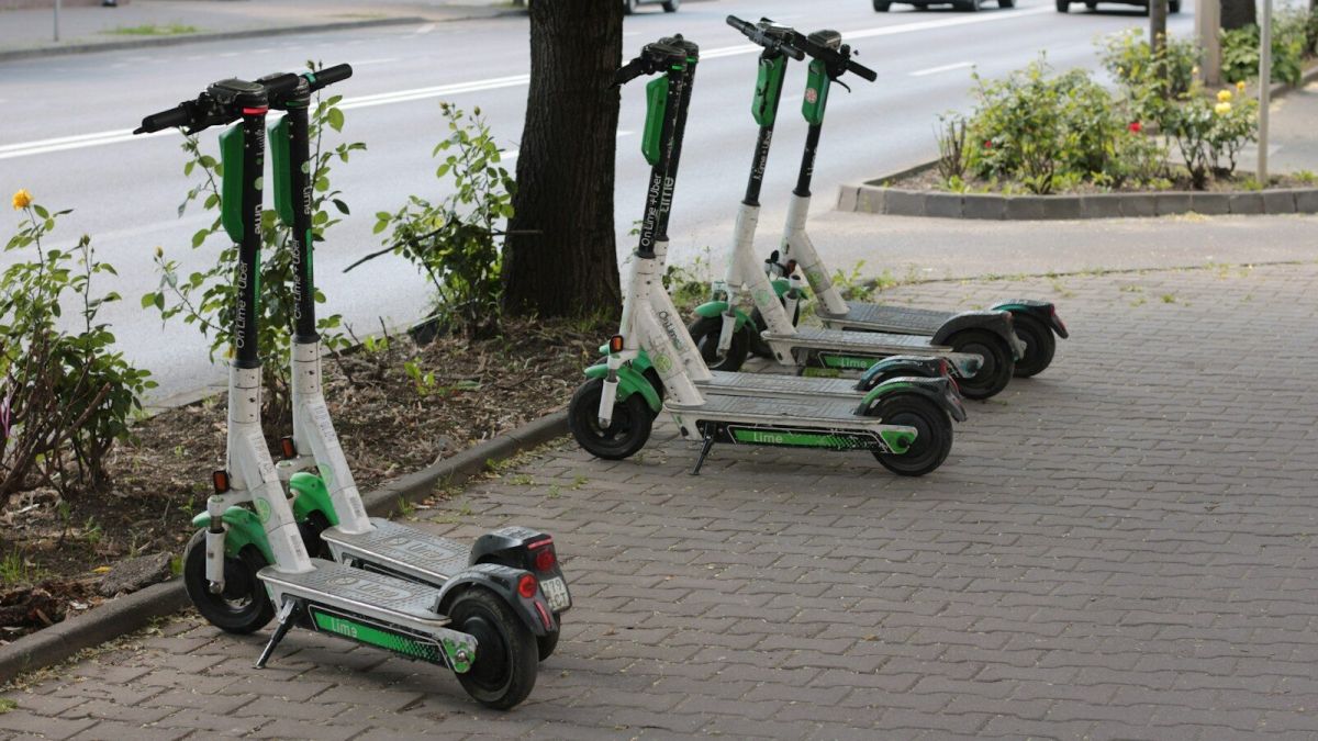 three green and white scooters parked on the side of the road
