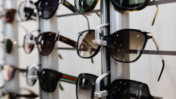 Close-up view of stylish sunglasses displayed on a rack in a retail store.
